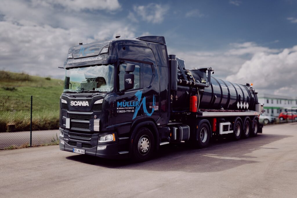 Ein schwarzes Saug- und Spülfahrzeug der Müller Kanaltechnik steht auf dem Betriebshof.